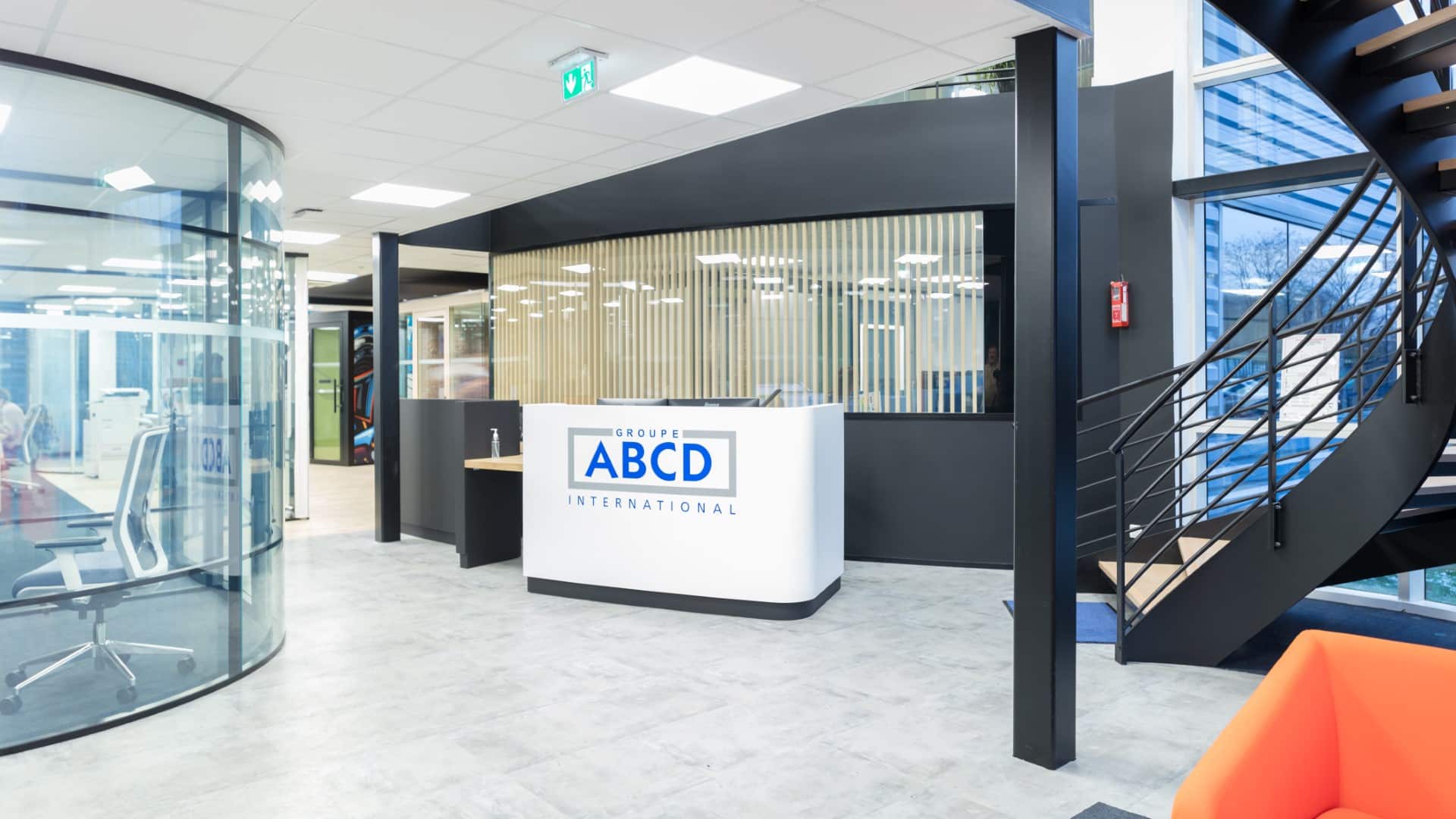 Espace de réception réaménagé et banque d’accueil conçue par EVIDENCE intérieurs, agence d’aménagement intérieur d’espaces tertiaires, pour ABCD International, fabricant de cloisons démontables de bureaux.